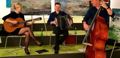 Drei Mitglieder der Familie Runggatscher spielen Gitarre, Ziehharmonika und Cello und sorgen damit für die musikalische Umrahmung beim Tiroler Demenzsymposium 2020.